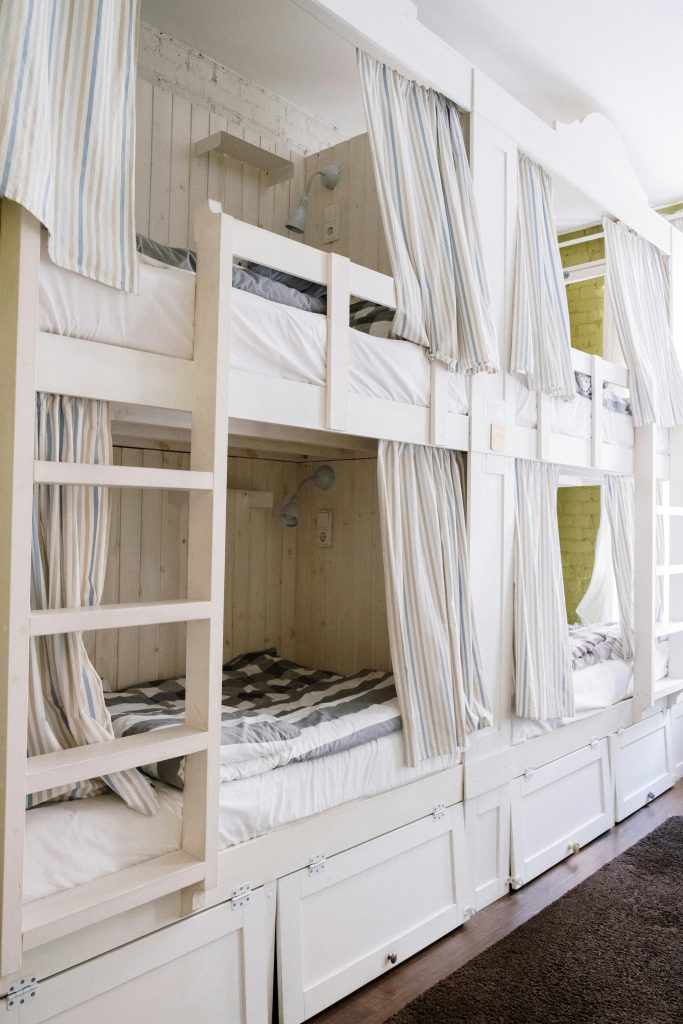 A modern dorm room featuring cozy bunk beds with privacy curtains and built-in storage.